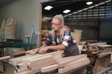 Contemporary Carpenter Working, Portrait of modern carpenter making wood furniture while working in joinery lit by sunlight with factory background on small business concept, copy space