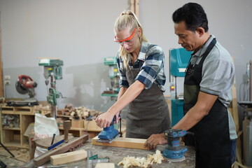 Contemporary Carpenter Working, Portrait of modern carpenter making wood furniture while working in joinery lit by sunlight with factory background on small business concept, copy space