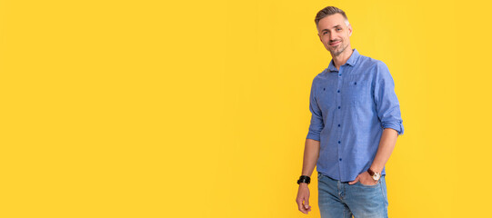 smiling mature man with wrist watch on yellow background, fashion. Man face portrait, banner with...