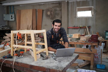 Contemporary Carpenter Working, Portrait of modern carpenter making wood furniture while working in joinery lit by sunlight with factory background on small business concept, copy space