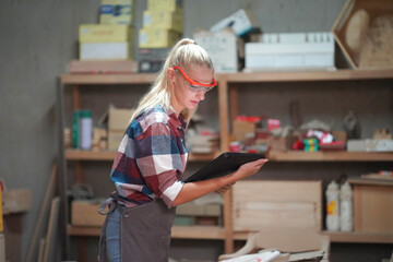 Contemporary Carpenter Working, Portrait of modern carpenter making wood furniture while working in joinery lit by sunlight with factory background on small business concept, copy space