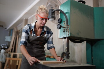 Contemporary Carpenter Working, Portrait of modern carpenter making wood furniture while working in joinery lit by sunlight with factory background on small business concept, copy space