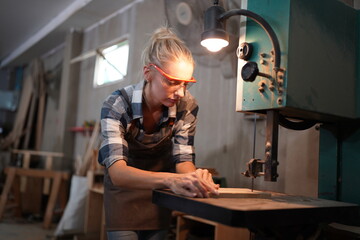 Contemporary Carpenter Working, Portrait of modern carpenter making wood furniture while working in joinery lit by sunlight with factory background on small business concept, copy space