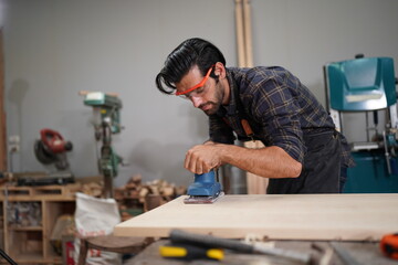 Contemporary Carpenter Working, Portrait of modern carpenter making wood furniture while working in joinery lit by sunlight with factory background on small business concept, copy space