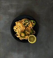 chinese new year with spaghetti and orange on black background 