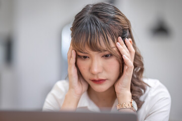 Young Business Asian women are stressed while working on laptop, Tired asian businesswoman with headache at office, feeling sick at work copy space in workplace an home office.