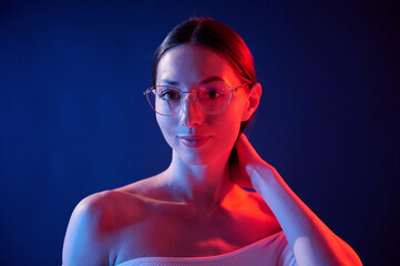 Conception of bad sight, in glasses. Portrait of young woman that is indoors in neon lighting