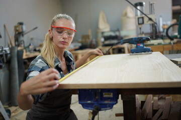 Contemporary Carpenter Working, Portrait of modern carpenter making wood furniture while working in joinery lit by sunlight with factory background on small business concept, copy space