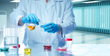 Laboratory technician. Scientists hands with test tubes. Flasks with multi-colored liquid on laboratory table. Scientific research. Laboratory technician during work. Chemistry, medicine, biology