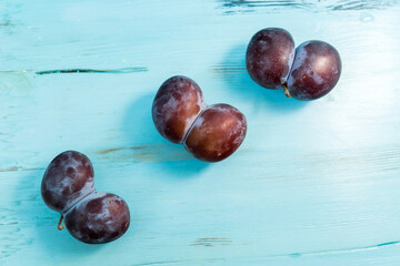 Ugly plum fruit, blue background. Concept reduction of food waste. The use of imperfect foods for...