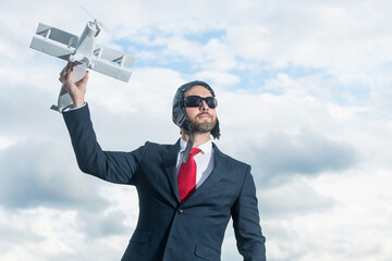 businessman in suit and pilot hat launch plane toy. freedom