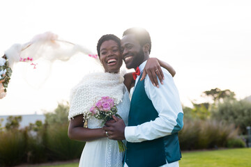Portrait of happy african american couple holding hands during wedding
