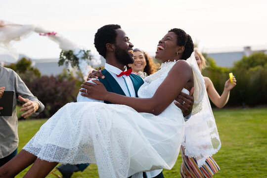 Happy african american couple smiling and carrying during wedding
