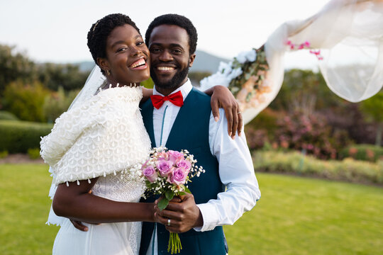 Portrait of happy african american couple holding hands during wedding