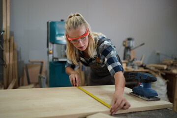 Contemporary Carpenter Working, Portrait of modern carpenter making wood furniture while working in joinery lit by sunlight with factory background on small business concept, copy space