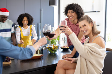 Happy diverse friends with santa hat cooking at christmas