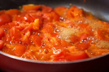 Cooking fresh tomatoes, sauce, ketchup, soup in a saucepan. Selective focus
