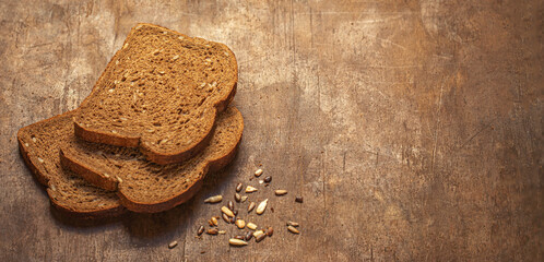 Fototapeta na wymiar Wholegrain bread on dark ructic wooden background. Fresh bread Top view. Copyspace.