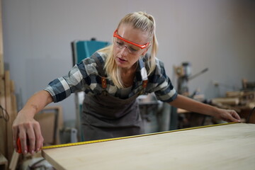 Contemporary Carpenter Working, Portrait of modern carpenter making wood furniture while working in joinery lit by sunlight with factory background on small business concept, copy space