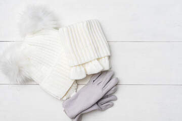 cozy knitted winter set. warm baby clothes, top view on a white wooden background