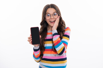 Fototapeta premium Mobile online shopping. Cute teen child girl paying with phone, texting and chatting on smartphone. Kid showing blank screen mobile phone, mock up copy space.