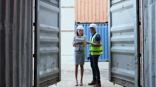 Businessman worker open door of cargo containers worker then use barcode scanner check the product for import and export and work with co-worker women at container yard
