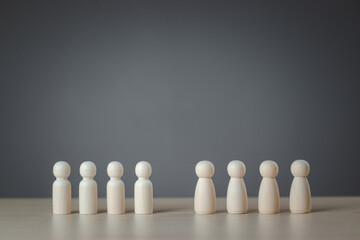 The wooden figure that is split in two on a gray background is like a man on one side and a woman on the other. Concept of equality gender diversity inequality. wooden puppet, wooden doll.