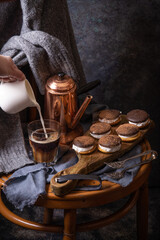 Fototapeta na wymiar Coffee, cakes and cozy sweater in dark style as autumn season concept. Copy space