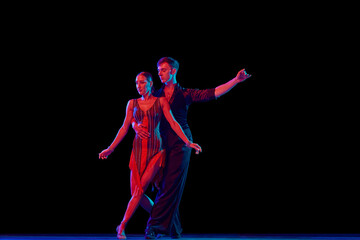 Feelings in dance. Emotional dancers dancing ballroom dance isolated on dark background. Concept of art, dance, beauty, music, style.