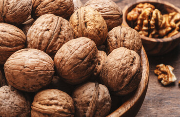 Fresh raw walnuts, autumn food background, nuts harvest. Old rustic wooden background, top view, close up