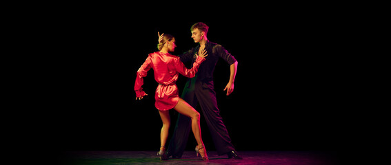 Feelings in dance. Emotional dancers dancing ballroom dance isolated on dark background. Concept of art, dance, beauty, music, style.