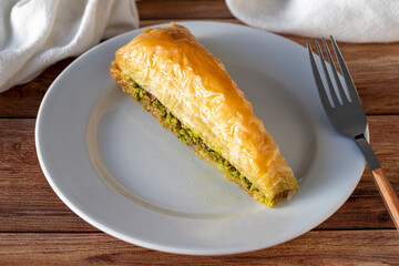 Pistachio baklava or carrot slice baklava on wooden background. Traditional Turkish cuisine...