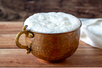 Sparkling buttermilk in a copper glass. Traditional Turkish food. Drink made with yogurt. close up