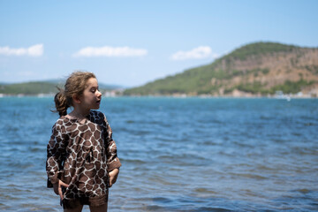 little girl in summer clothes poses by the sea. Selective Focus girl