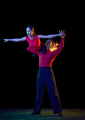 Obraz premium Support. Sensual young dancers dancing ballroom dance isolated on dark background. Concept of art, dance, beauty, music, style.