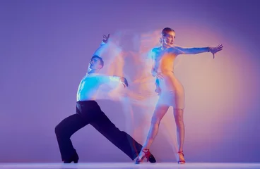 Foto op Canvas Jonge sierlijke dansers, flexibele man en vrouw dansen ballroomdans geïsoleerd op gradiënt blauw paarse achtergrond in neon gemengd licht. © master1305