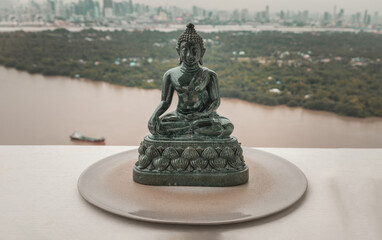 Figurine of Emerald lord buddha gautama or Siddhattha gotama buddha sculpture statue with nature background. Space for text, Selective focus.