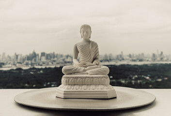 White figurine of siddhartha gautama buddha sculpture statue with nature background. Space for...