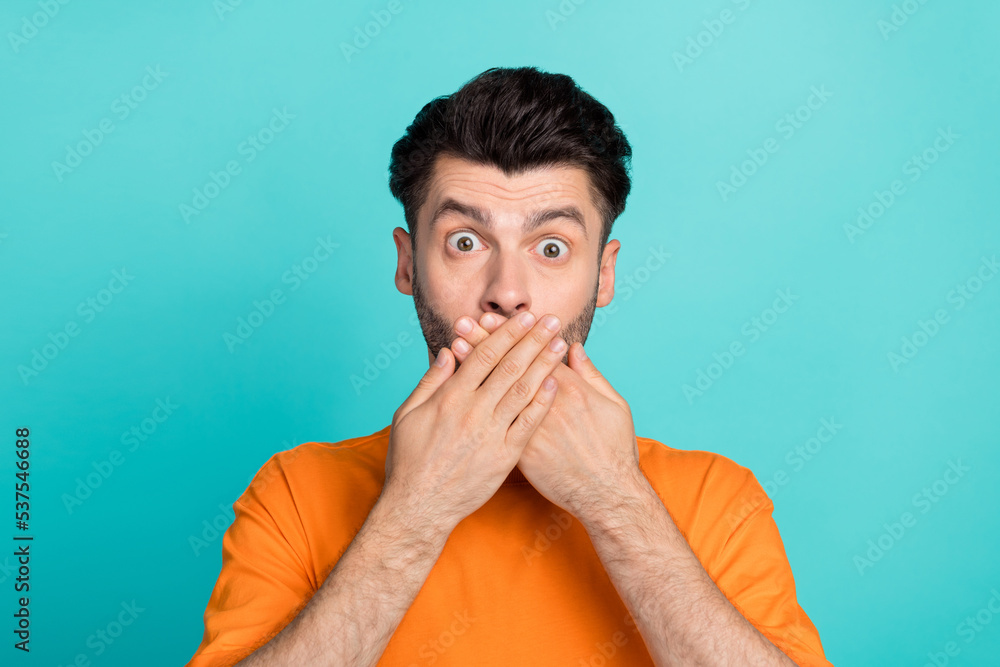 Poster closeup photo of young attractive funny face man student wear orange t-shirt cover hands mouth scare