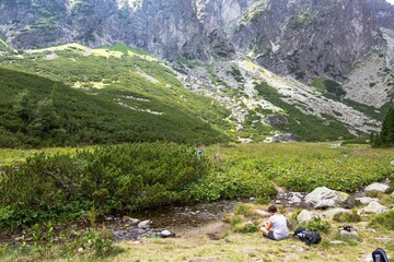 Man hiker sitting in Velka Studena dolina valley in Slovakia on a cloudy day © Szabi Bella/Wirestock Creators