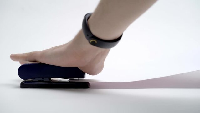 A man fastens paper with a stapler, close-up, only his hands are in the frame, on a white background, isolated