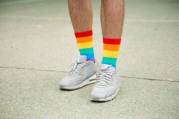Fototapeta na wymiar Feet with trainers and rainbow socks