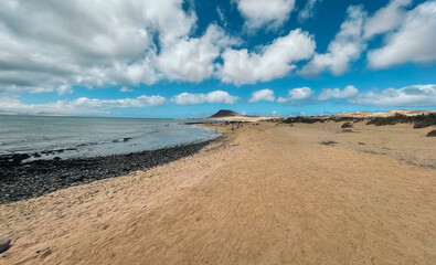 Fototapeta na wymiar Sandy beach and sea against cloudy sky