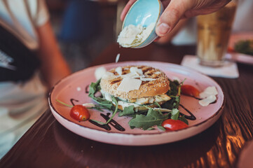 Bagel mit Hummus, Serranoschinken, Rucola, Cherry-Tomaten und Balsamicocreme