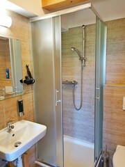 Bathroom with shower, sink, mirror and other equipment