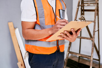Cropped shot of supervisor checks renovation project with checklist on clipboard