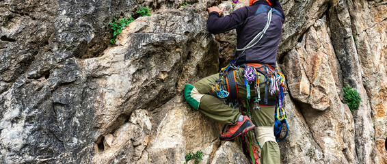 man climbs an overhanging rock with rope, lead climbing. Adventurous Extreme Sport concept.
