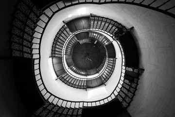 Grayscale top view of an indoor spiralling staircase