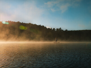 Woman paddling on sup board on Sunrise
