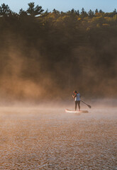Woman paddling on sup board on Sunrise